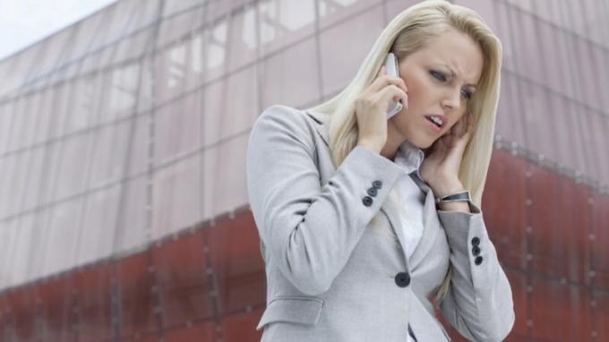 ADHD-ga naine kuulab kedagi mobiiltelefonil ja vihastab kõrge hoone ees